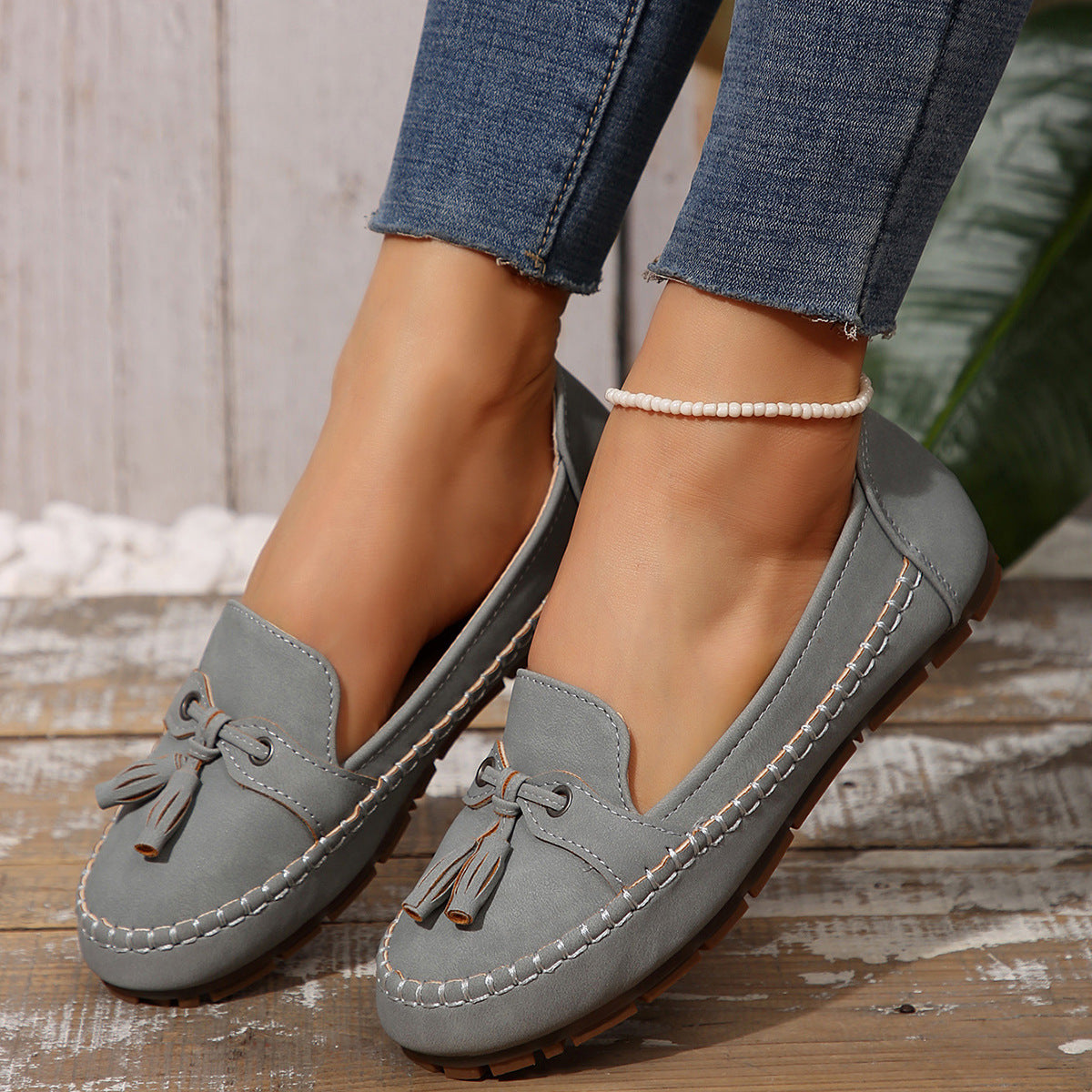 Women’s light gray suede loafers with round toe, tassel lace, stitched flat sole