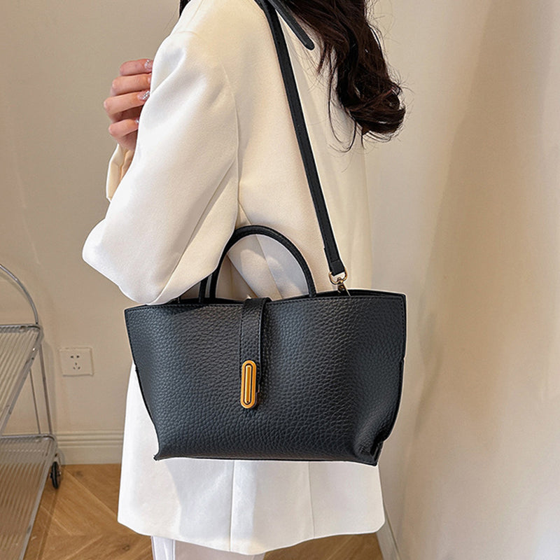 Black textured PU bucket tote bag with front zipper and crossbody strap.