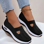 Black mesh slip-on flat shoes with oval cutouts and white cushioned soles