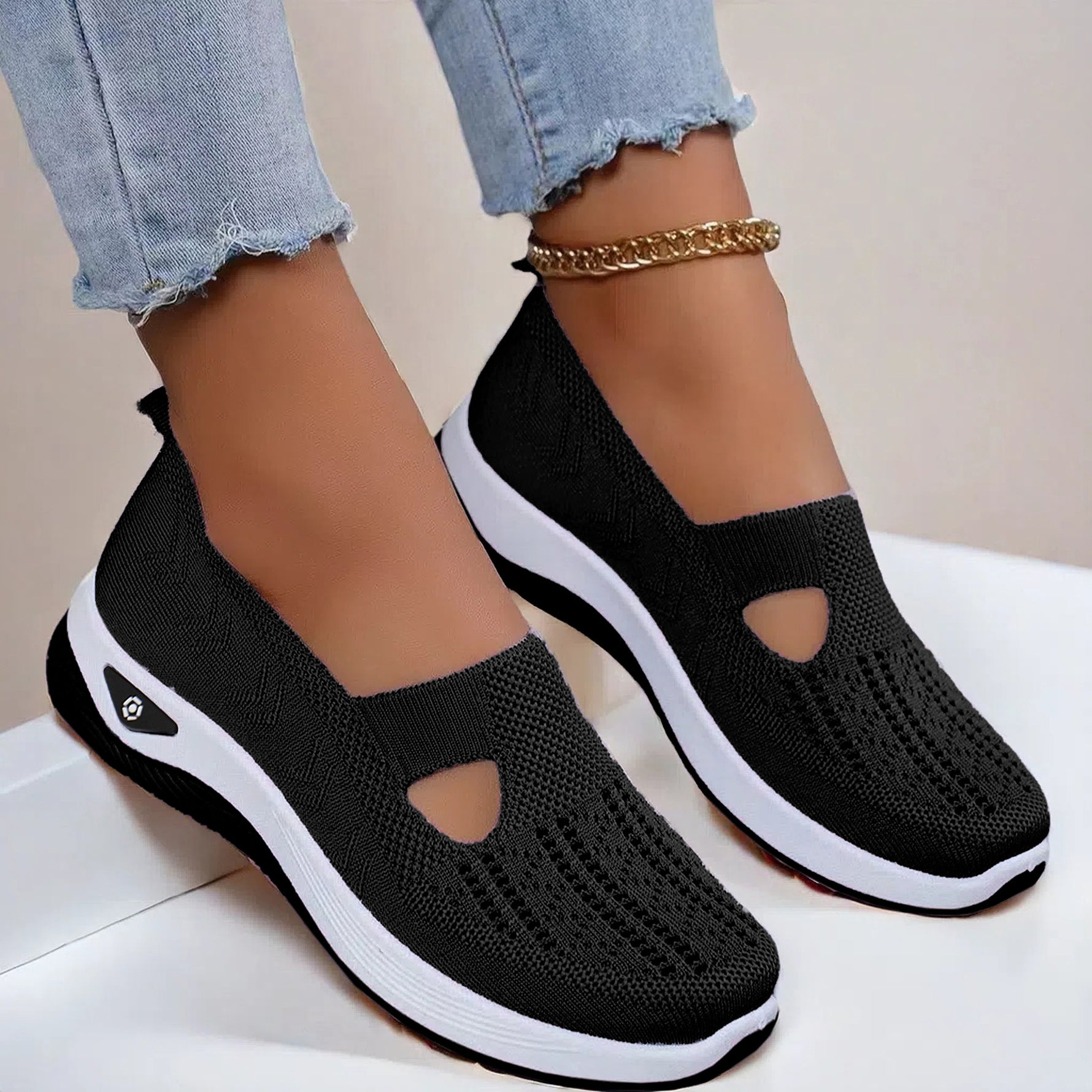 Black mesh slip-on flat shoes with oval cutouts and white cushioned soles