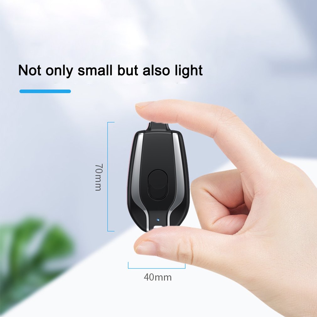Black mini keychain power bank charger held in hand, compact pod with charging connector