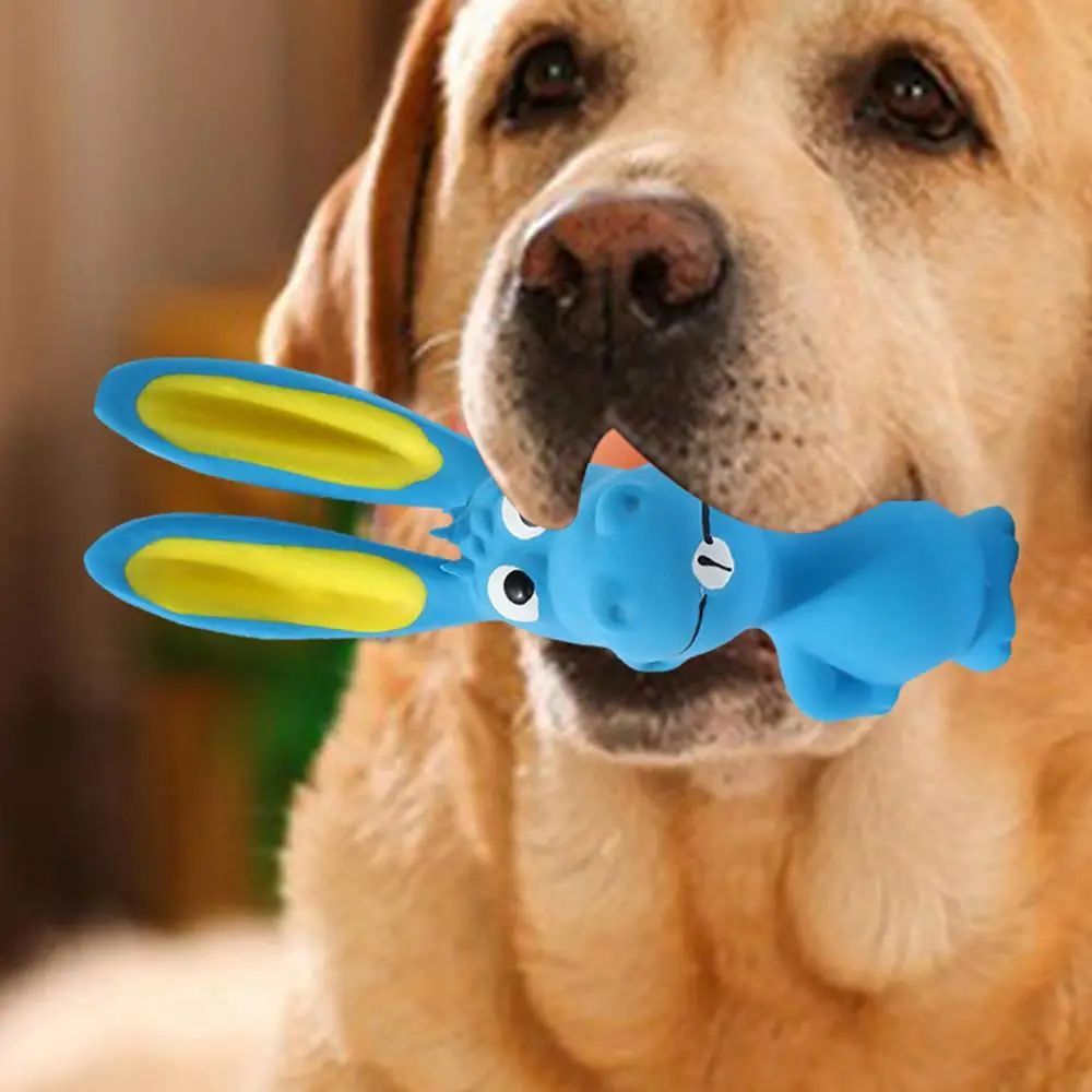 Blue latex rabbit squeaky chew toy with yellow inner ears held near dog