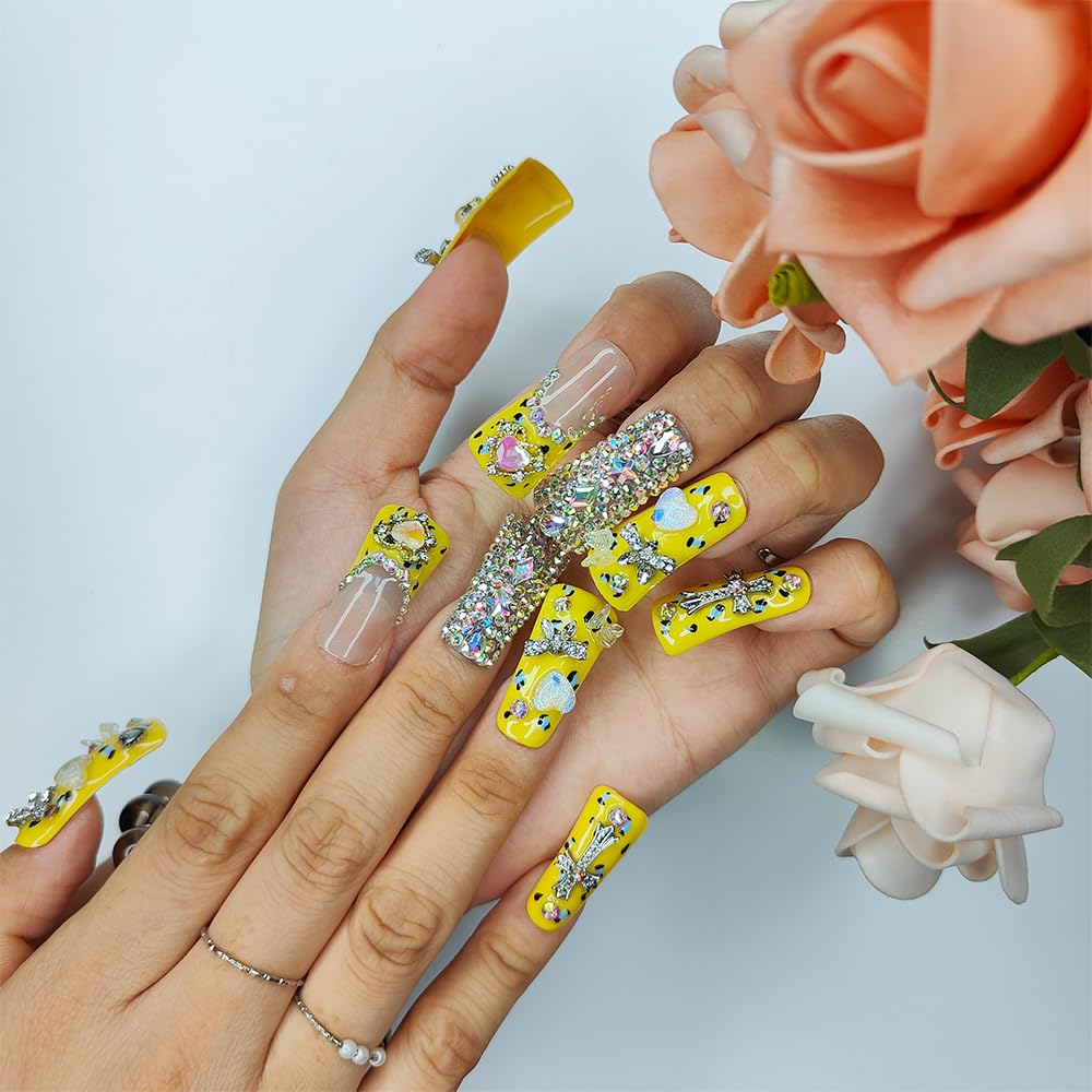 Duck-themed yellow rhinestone nails on hand, medium square with nude tips