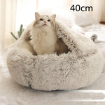 Light grey round plush pet bed with long shag rim, cat curled up inside.