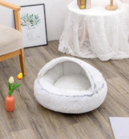 Round white plush pet bed with raised rim and cozy nesting center