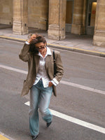 Plaid blazer with notch lapels and long sleeves, styled over a white button-up shirt
