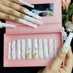 White press-on nails with bow and bear-face embellishments, several tips shown