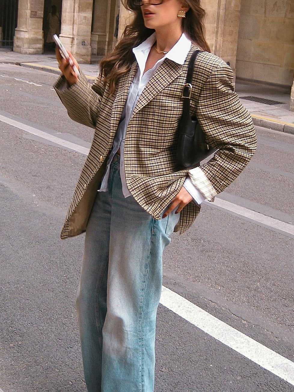 Plaid blazer with notch lapels and long sleeves, worn over a white button-up shirt