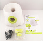 White dog ball launcher kit with lime-green chute, tennis balls, and power cord