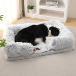Light gray plush dog bed with rounded bolsters and cushioned base