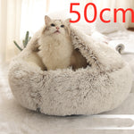 Light grey round plush pet bed with shag rim, cat sitting inside.