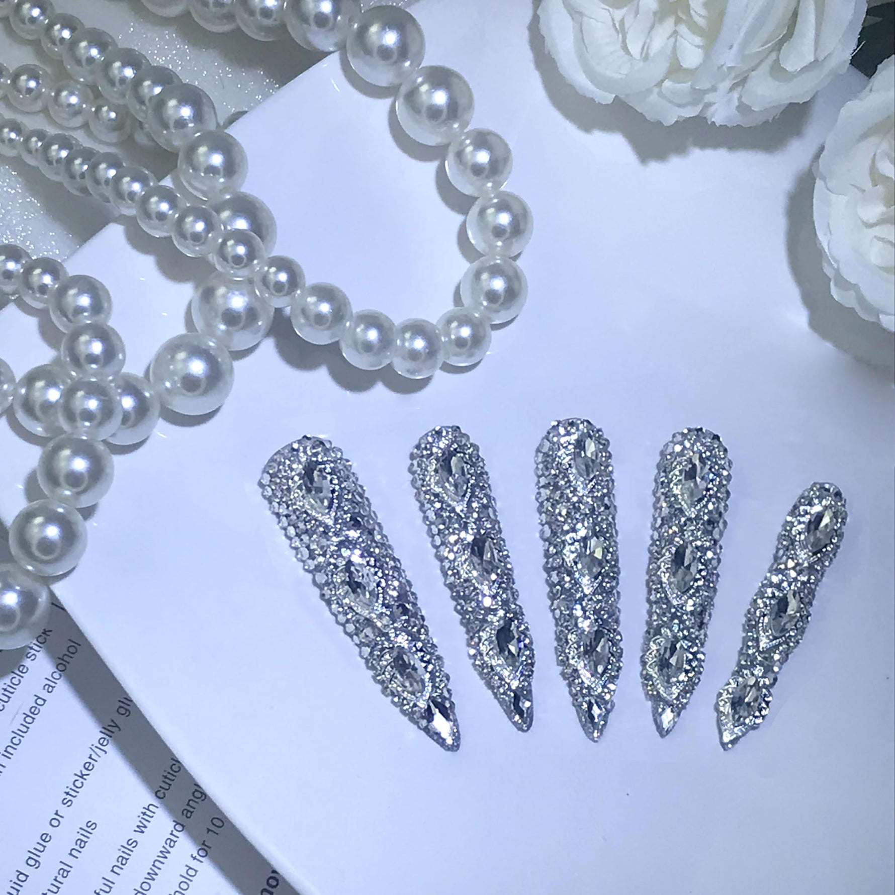 Long almond silver crystal press-on nails with oval jeweled center rhinestone details