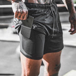 Black pocket compression shorts with side phone holder and elastic waistband