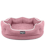 Pink round removable pet bed mattress with white piping and logo patch on front