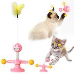 Pink windmill cat toy with smiling ball on spring and orange ball accents