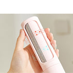 Pink reusable lint roller pet hair remover brush held in hand