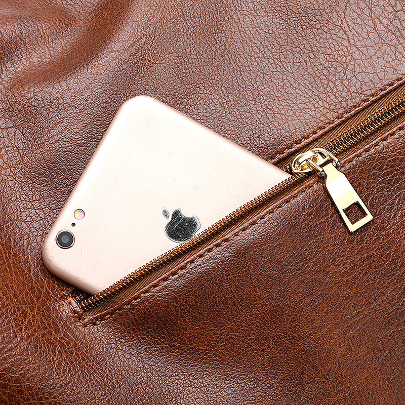 Brown hobo bucket bag front pocket with zipper and phone resting inside