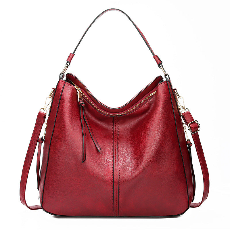 Red hobo bucket bag with zipper top, side pockets and shoulder straps