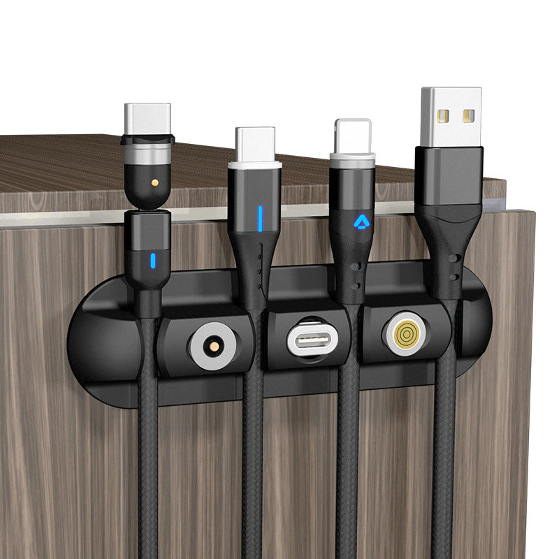 Black magnetic desktop cable organizer with four cable holders and soft plastic base