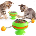 Rotatable cat training toy with green base, amber dome, spring track and ball