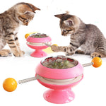 Rotatable cat training toy with pink base, amber dome, spring track and ball