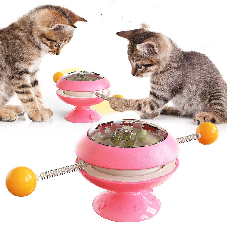 Rotatable cat training toy with pink base, amber dome, spring track and ball