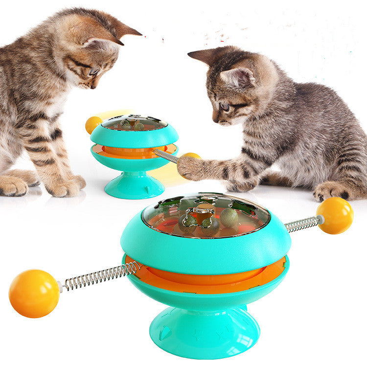 Rotatable cat training toy with teal base, amber dome, spring track and ball