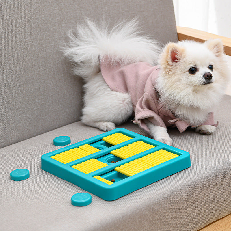 Teal slow-feeding dog toy with yellow ridged compartments and paw-shaped button lids