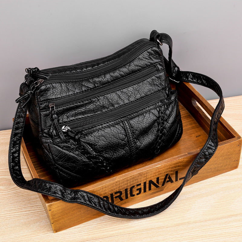 Black soft PU leather messenger bag with three zip compartments and adjustable crossbody strap
