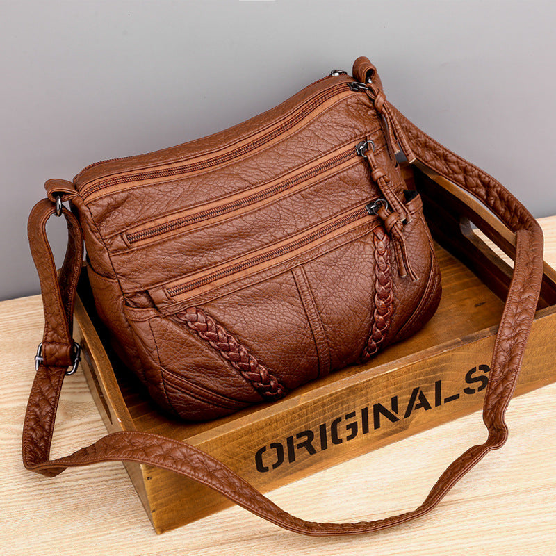 Brown soft PU leather messenger bag with braided front, multiple zippers, and shoulder strap