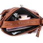 Brown leather-look messenger bag open, showing inner pockets and zipper compartments