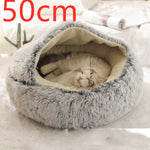Grey round plush pet bed with shag rim and hooded cradle, cat sleeping inside.