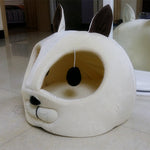 Cat-shaped pet bed, white plush with one oval side opening and black pom-pom nose