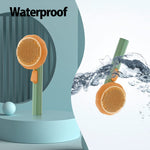 Pet grooming slicker brush with orange head and green handle with visible water droplets