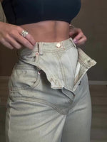 Light green high-waist denim jeans close-up, side details and buttoned waistband
