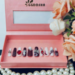 Shiny press-on long nails set with red, white, and dark purple accents and rhinestones