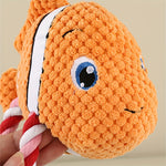 Orange turtle-shaped plush dog chew toy with white stripe and rope limbs