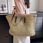 Woven shoulder beach bag in light beige with black handles and long shoulder strap