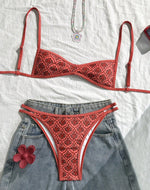 Two-piece bikini set with red patterned triangle top and matching high-cut bottoms, laid flat