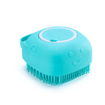 Teal silicone pet bath massage brush with rounded face details and soft bristles