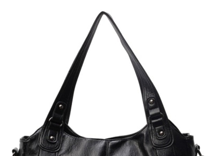 Women’s retro PU handbag top area in black, with double buckle handles and metal studs.