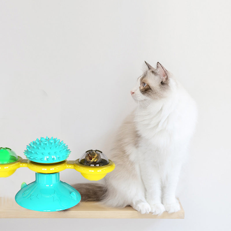 Cat rotating windmill toy with turquoise spiky top and yellow and clear rotating bowls