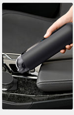 Handheld wireless car vacuum nozzle cleaning a car seat seam