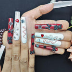 Long press-on nails on hands, red and white glossy tips with bows, hearts, roses, crystals