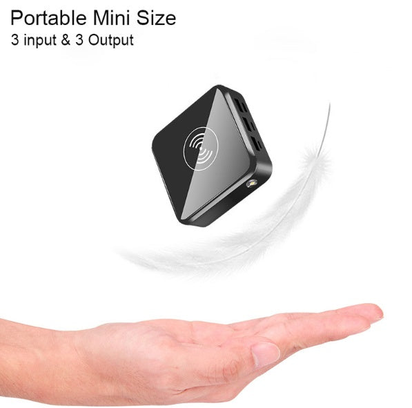 Black mini power bank resting in an open palm with wireless charging icon