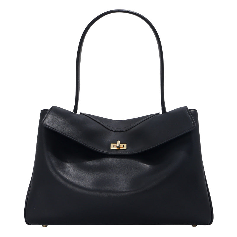 Black leather tote bag with top handle and center gold-tone clasp