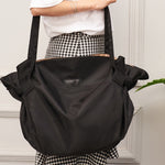 Black Oxford cloth shoulder messenger bag with front logo patch and side buckle straps