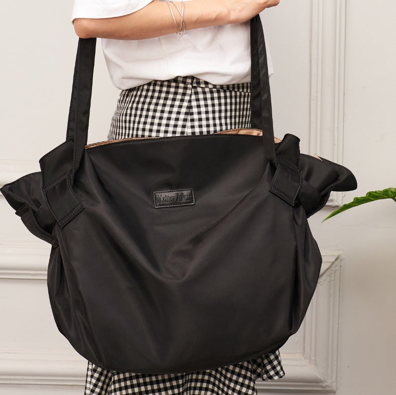 Black Oxford cloth shoulder messenger bag with front logo patch and side buckle straps