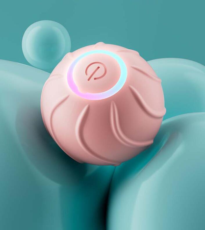 Interactive cat rolling ball toy in pink with glowing power button
