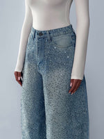 Light blue denim jeans with rhinestone speckle, high-rise waistband, button front